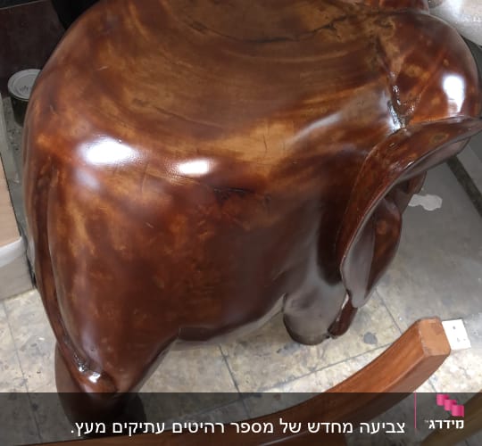 פסל עץ של פיל על רצפה מרוצפת
